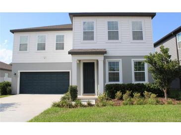 Charming two-story home featuring a well-manicured lawn and an attached two-car garage at 5725 Iron Brand Rd, St Cloud, FL 34771