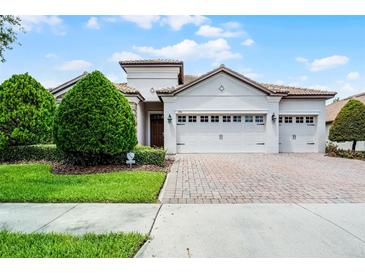 Charming single-story home with a tile roof, three-car garage and manicured landscaping at 1394 Palmetto Dunes St, Champions Gate, FL 33896