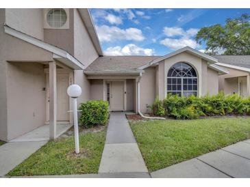 Charming townhome exterior with well-maintained landscaping and an arched window at 1651 Windsor Oak Ct, Kissimmee, FL 34744