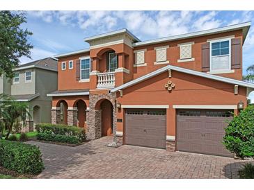 Charming two-story home features a brick driveway, a two-car garage, and manicured landscaping at 341 Lasso Dr, Kissimmee, FL 34747