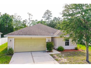 Charming one-story home featuring an attached two-car garage and a well-maintained, landscaped front yard at 56 Levee Ln, Ormond Beach, FL 32174