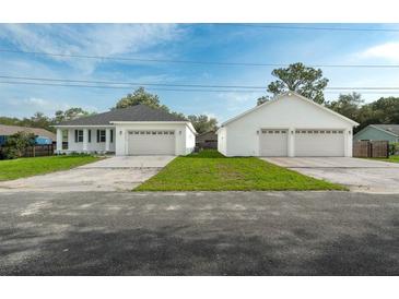 Bright home exterior featuring a well-manicured lawn and a spacious three-car garage for ample parking at 6479 Apple St, St Cloud, FL 34771