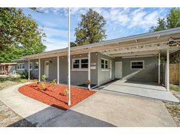 Charming single-story home featuring a covered carport, manicured landscaping, and a freshly painted facade at 807 E Airport Blvd, Sanford, FL 32773