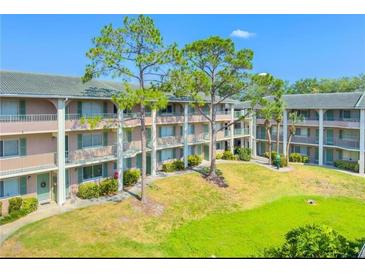 A charming condo complex with a manicured lawn and mature trees at 115 Oyster Bay Byu # 115, Altamonte Springs, FL 32701