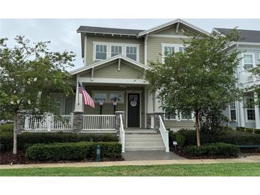 Charming two-story home with an American flag, a cozy front porch, and well-maintained landscaping at 1801 Coastal Ct, Celebration, FL 34747