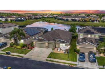 Beautiful home with a water view, solar panels, landscaped yard, and large driveway in a well-maintained community at 3698 Cortland Dr, Davenport, FL 33837