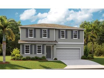 Charming two-story home boasts a manicured lawn, gray siding, and a convenient two-car garage at 1022 Wisteria Way, Dundee, FL 33838