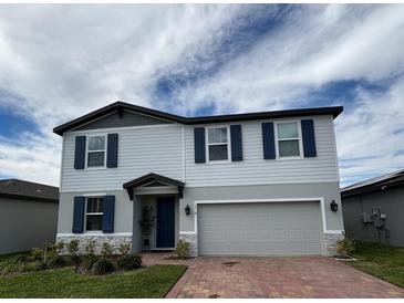 Charming two-story home with blue shutters, gray accents, and a red brick driveway at 1210 Zambrana Ct, Winter Haven, FL 33884