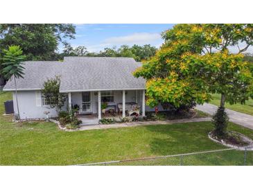Charming single-story home featuring a well-manicured lawn, inviting porch, and mature landscaping at 1640 Marks St, Kissimmee, FL 34746