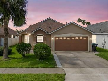 Charming single-Gathering home with a well-manicured lawn, lush landscaping, and a two-car garage at 2912 Lazlo Ln, Orlando, FL 32837