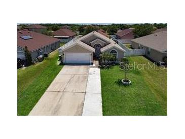 Charming single-story home with well-manicured lawn and a two-car garage at 3030 Eagle Crossing Dr, Kissimmee, FL 34746