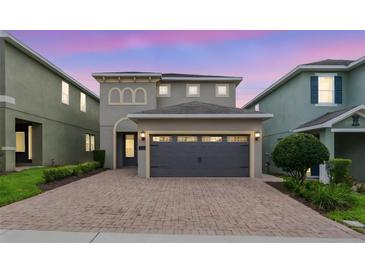 Charming home with a two-car garage, brick driveway, and manicured landscaping at 340 Pendant Ct, Kissimmee, FL 34747