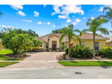 Charming single-story home with beautiful landscaping, brick driveway, and a tile roof in a sunny setting at 3427 Harborside Ct, Kissimmee, FL 34746