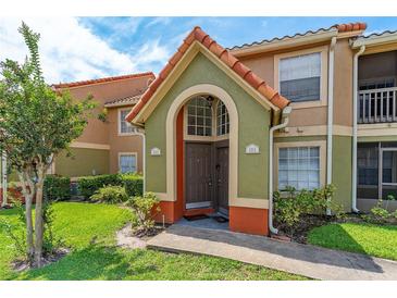 Charming condo exterior with a green and orange entrance and meticulously kept lawn at 437 Fountainhead Cir # 283, Kissimmee, FL 34741
