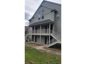 Two-story building featuring covered balconies and exterior staircases, set against a partly cloudy sky at 6148 Westgate Dr # 302, Orlando, FL 32835