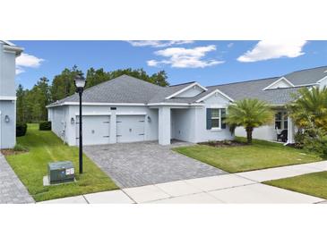 Charming single-story home featuring a two-car garage, paver driveway, and well-maintained landscaping at 3052 Prelude Ln, Kissimmee, FL 34746