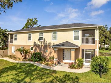 Charming two-story home with landscaped yard and screened-in porch under blue sky at 4899 Meadow Dr, St Cloud, FL 34772