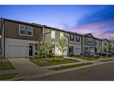 Charming townhomes with colorful facades and well-manicured landscaping on a peaceful street at 955 Grandin St, Davenport, FL 33837