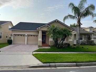 Charming single-Gathering home with well-maintained landscaping, lush lawn, and mature palm trees at 9721 Old Patina Way, Orlando, FL 32832
