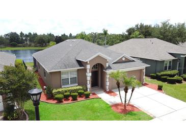 Well-maintained single Gathering home featuring a lush lawn, landscape beds, and inviting entryway at 9824 Secret Cove Ln, Orlando, FL 32832