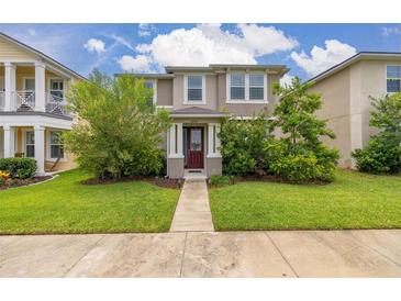 Charming two-story home with green lawn, landscaped shrubs, and light tan exterior paint at 11844 Founders St, Orlando, FL 32832