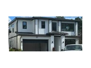 Modern two-story home with a two-car garage and sleek, dark window trim accents at 1327 Butterfly, Davenport, FL 33837