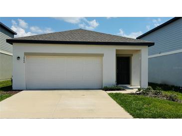 Charming single-Gathering home with a spacious two-car garage and well-manicured lawn on a sunny day at 2860 Poppy Avenue, Haines City, FL 33844