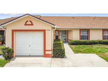 A charming single-story home features a one-car garage and well-maintained landscaping at 3428 Village Green Ct, St Cloud, FL 34772