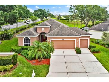 Beautiful single-Gathering home with attached two-car garage, mature landscaping, and a well-manicured lawn at 4065 Kingsley St, Clermont, FL 34711