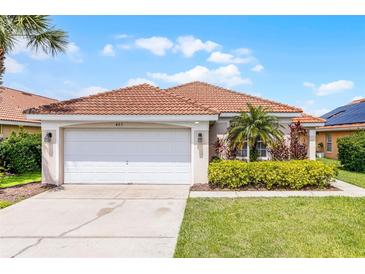 Charming home featuring a clay tile roof, well-maintained landscaping, and a two-car garage at 423 Paloma Dr, Davenport, FL 33837