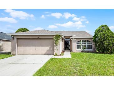 Charming single-story home with a well-manicured lawn and attached two-car garage at 440 Peppermill Cir, Kissimmee, FL 34758
