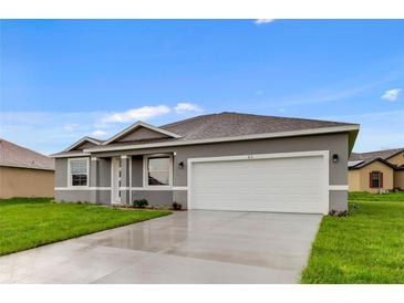 Charming one-story home with a two-car garage, fresh green lawn, and neutral color palette at 515 Everest Way, Kissimmee, FL 34758