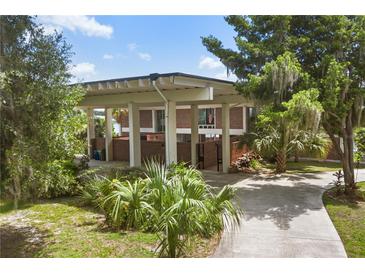 Modern brick home with an expansive covered entrance, lush landscaping and a charming walkway at 550 Lake Otis Se Dr, Winter Haven, FL 33880