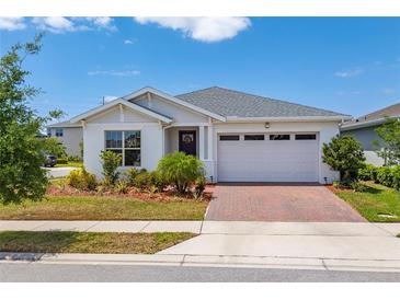 Charming single-story home with manicured landscaping and a brick paver driveway at 6651 Syreeta Ln, Harmony, FL 34773