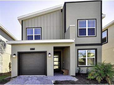 Contemporary two-story home with a modern design, featuring a gray exterior, clean lines, and a single-car garage at 8974 Cabot Cliffs Dr, Davenport, FL 33896