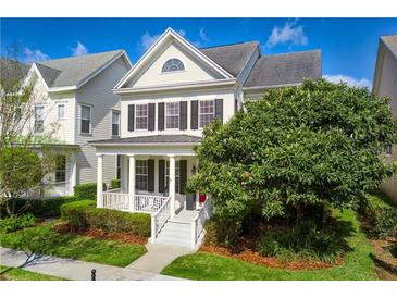 Charming two-story home featuring a welcoming porch and a well-maintained landscaped yard at 1236 Aquila Loop, Celebration, FL 34747