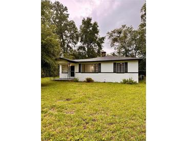 Charming single-story home with a well-maintained lawn and mature trees at 1615 Ne 9Th St, Ocala, FL 34470