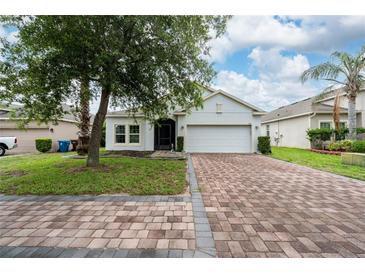 Charming single-story home features a brick driveway and lush green lawn at 205 Lakeshore Dr, Davenport, FL 33837