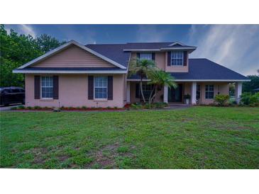 Charming two-story home featuring manicured lawn and a welcoming front porch at 2851 Granada Blvd, Kissimmee, FL 34746