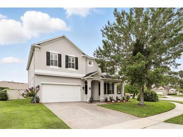 Charming two-story home with a brick driveway, a well-manicured lawn, and manicured shrubbery at 3859 Spirited Cir, St Cloud, FL 34772