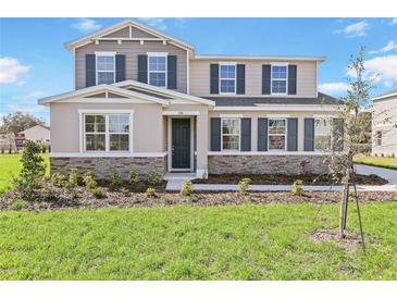 Charming two-story home featuring a stone veneer, neutral colors, and well-maintained landscaping at 530 Summit River Dr, Apopka, FL 32712