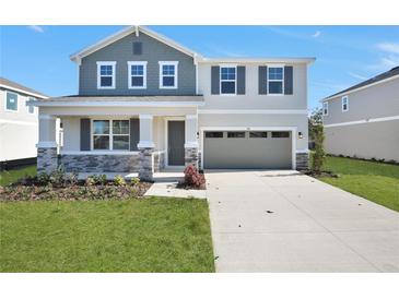 Charming two-story home featuring stone accents, gray shutters and an attached two car garage at 545 Summit River Dr, Apopka, FL 32712
