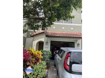 Charming two-story townhome with a red tile roof and an attached one-car garage at 5930 Tivoli Gardens Blvd, Orlando, FL 32829