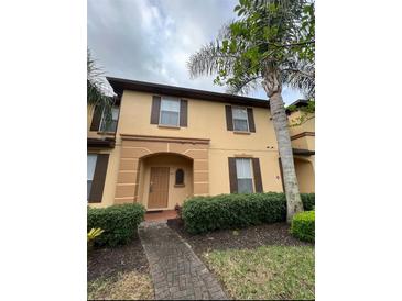 Charming two-story townhome featuring a beautifully landscaped yard and inviting entryway at 615 Terra Lago St, Davenport, FL 33897