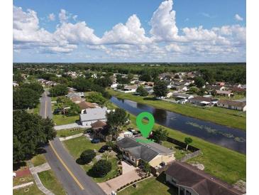 An aerial view of the home and its neighborhood with a canal in the back at 624 Royal Palm Dr, Kissimmee, FL 34743