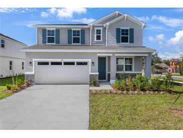Charming two-story home featuring gray siding, stone accents, an attached two-car garage and a well-manicured front lawn at 640 Summit River Dr, Apopka, FL 32712