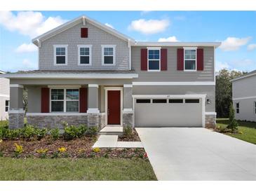 Charming two-story home with a well-manicured lawn and a two-car garage with red shutters at 655 Summit River Dr, Apopka, FL 32712