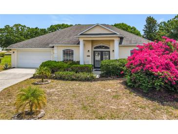 Charming single-story home with lush landscaping and bright pink bougainvillea in the front yard at 116 Westport Ln, Davenport, FL 33896