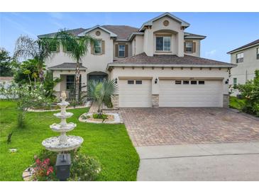 Beautiful two-story home with a well-manicured lawn, water fountain, and a three-car garage at 16072 Shasta St, Clermont, FL 34714