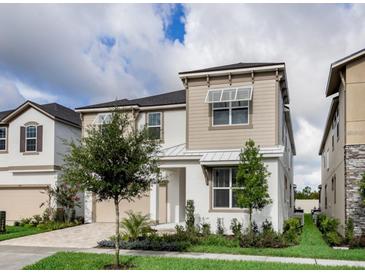 Charming two-story home features a combination of stucco and siding, complemented by green grass and trees at 1810 Caribbean View Ter, Kissimmee, FL 34747
